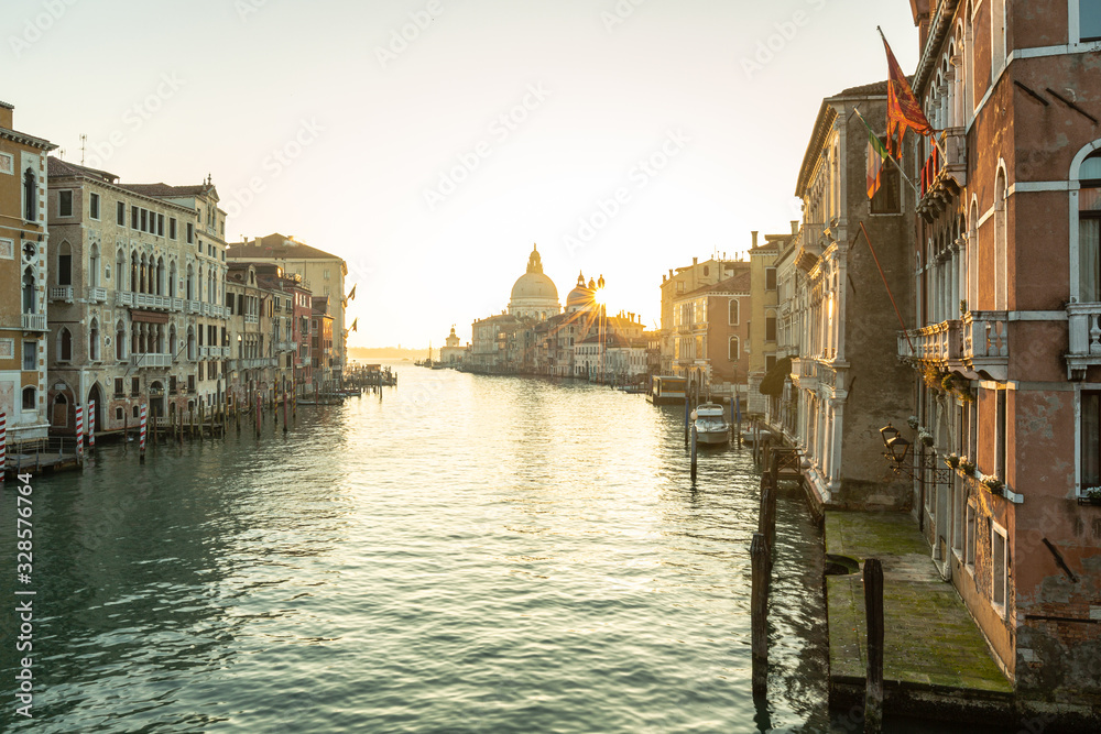Naklejka premium canal in Venice, sunrise over the church