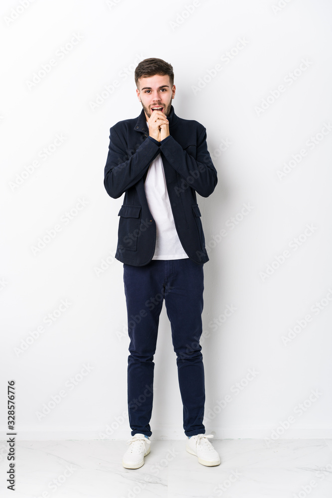 Full body young caucasian man isolated praying for luck, amazed and opening mouth looking to front. Full body young caucasian man isolated praying for luck, amazed and opening mouth looking to front.
