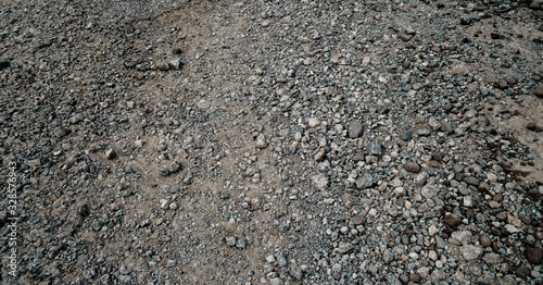 Gray gravel scattered on the ground, suitable for grunge or rustic rough theme background designs.