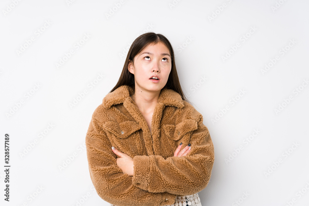 Young chinese woman posing in a white background isolated tired of a repetitive task. Young chinese woman posing in a white background isolated tired of a repetitive task.