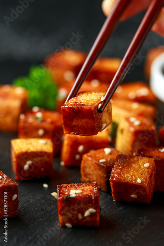 Canvas Print Fried Tofu with chopstick and sesame seeds on rustic stone board