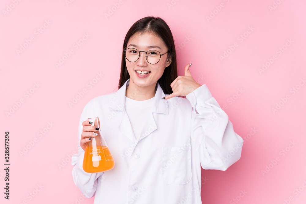Young chinese scientific woman isolated showing a mobile phone call gesture with fingers. Young chinese scientific woman isolated showing a mobile phone call gesture with fingers.