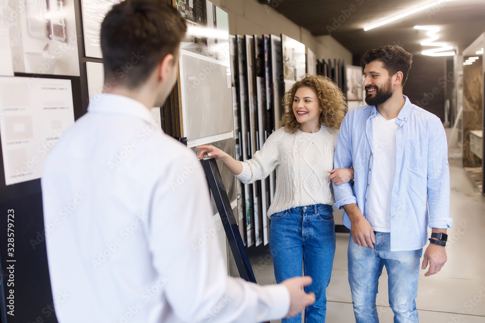 Obraz premium Happy and smiling couple choosing ceramic tile for house