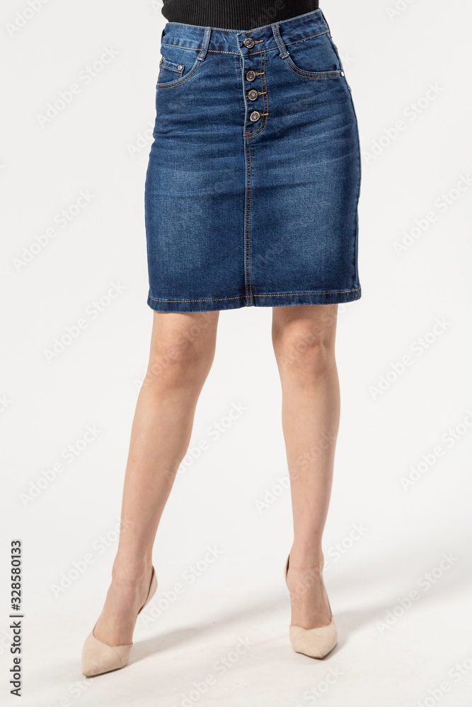 girl in a denim short skirt and high heels on a white background