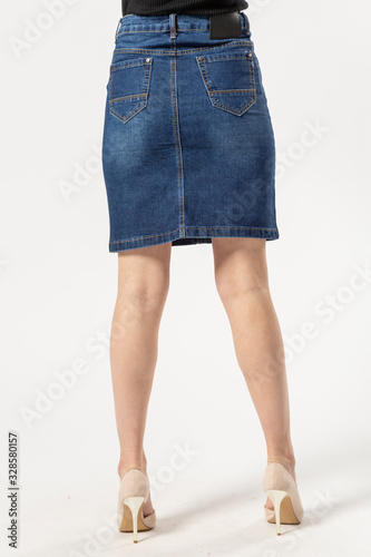 girl in a denim short skirt and high heels on a white background