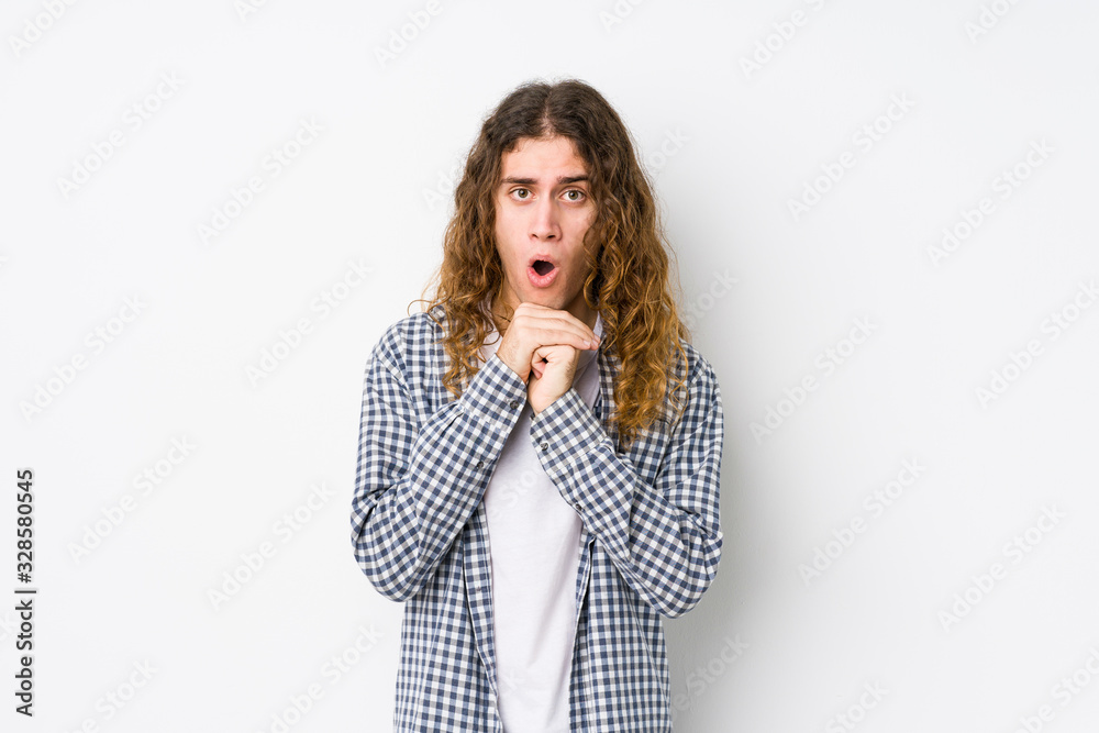 Young long hair man posing isolated praying for luck, amazed and opening mouth looking to front. Young long hair man posing isolated praying for luck, amazed and opening mouth looking to front.