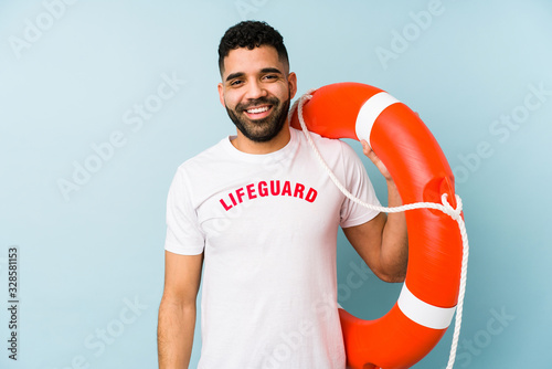 Young latin lifeguard man isolated happy, smiling and cheerful. © Asier