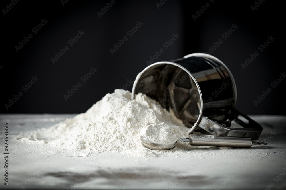 Flour on a kitchen table on a black moody background in the morning light