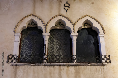 Tre finestre caratteristiche in centro storico con tende alle finestre. Portogruaro, Veneto. Italia. photo