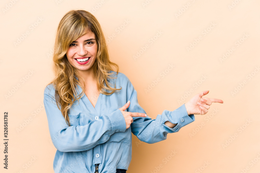 Young blonde caucasian woman excited pointing with forefingers away. Young blonde caucasian woman excited pointing with forefingers away.