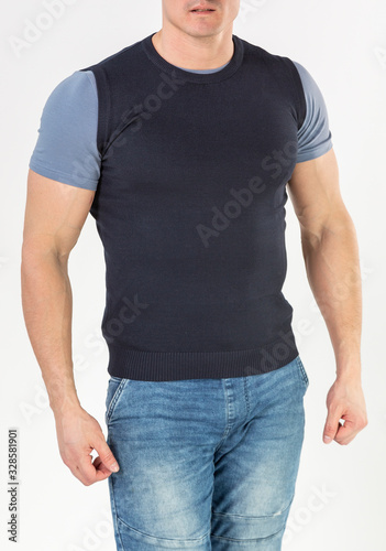 a man in a knitted vest and blue jeans on a white background