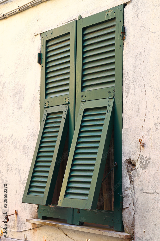 Fototapeta premium Beautiful Green shuttered windows in Italy.