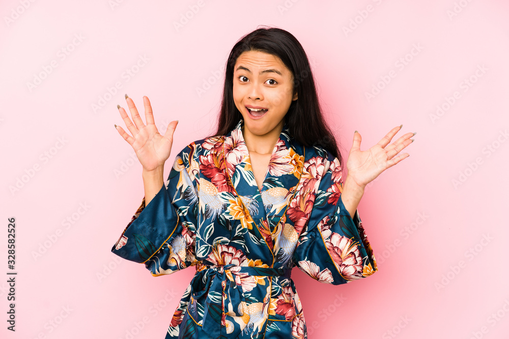 Young chinese woman wearing a asiatic pijama isolated pointing to the side Young chinese woman wearing a asiatic pijama isolated pointing to the side