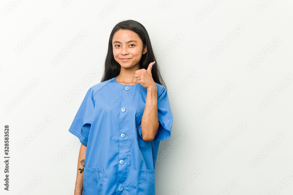 Young asian nurse woman smiling and raising thumb up Young asian nurse woman smiling and raising thumb up