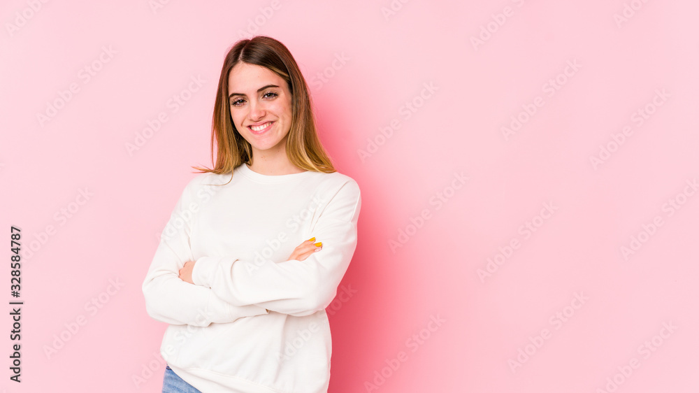 Young caucasian woman isolated on pink background who feels confident, crossing arms with determination. Young caucasian woman isolated on pink background who feels confident, crossing arms with determination.
