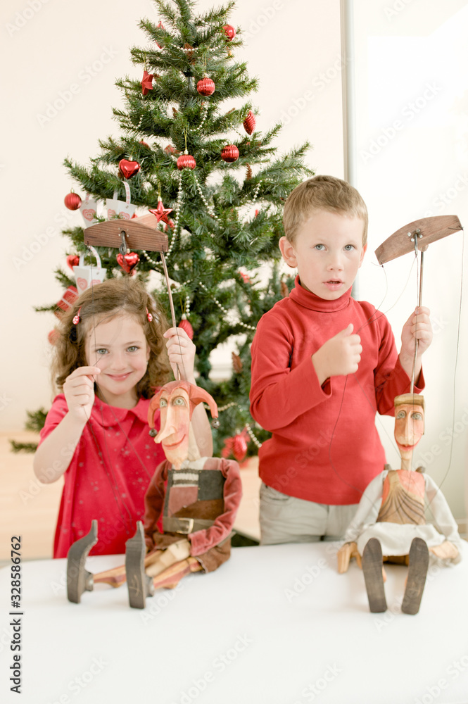 Happy children playing with puppets and enjoying Christmas atmosphere Happy children playing with puppets and enjoying Christmas atmosphere