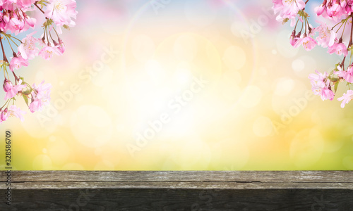 A wooden table top product display with a pink cherry tree blossom flowers blooming in spring Easter sunrise for a Mothers Day background.