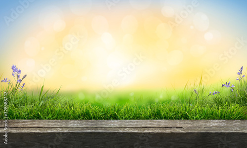Obraz na płótnie A wooden table top product display with a fresh summer sunny blue sky with warm bokeh background with green grass meadow foreground. w salonie