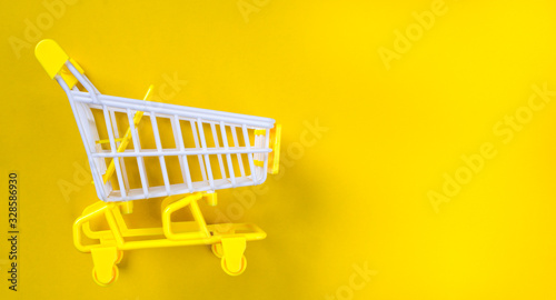 Shopping trolley over yellow background