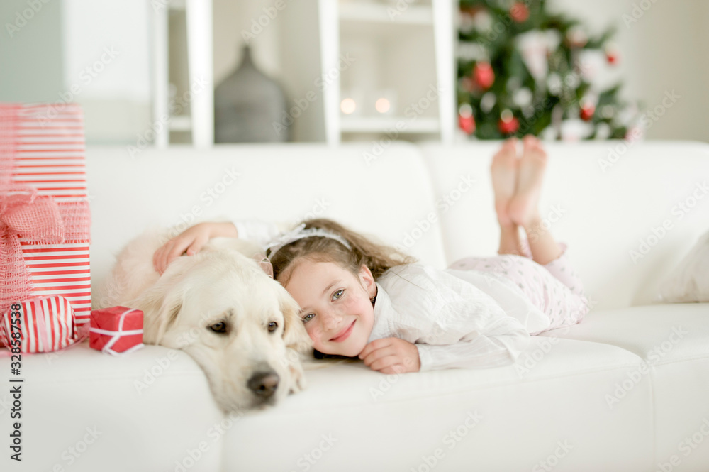 Cute little child with golden retriever dog enjoying Christmas atmosphere Cute little child with golden retriever dog enjoying Christmas atmosphere