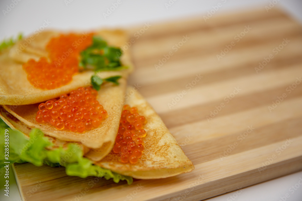 Pancake caviar on a wooden board isolated background Pancake caviar on a wooden board isolated background