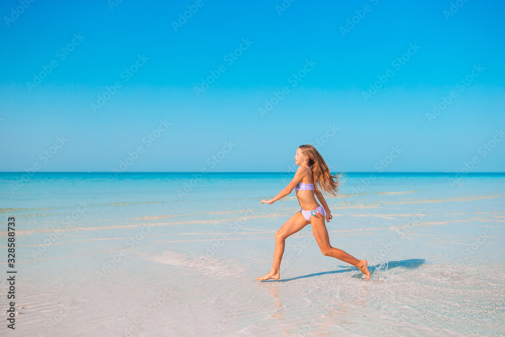 Adorable active little girl at beach during summer vacation Adorable active little girl at beach during summer vacation
