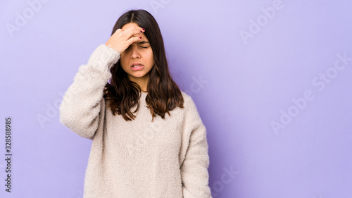 Young mixed race hispanic woman isolated having a head ache, touching front of the face. © Asier