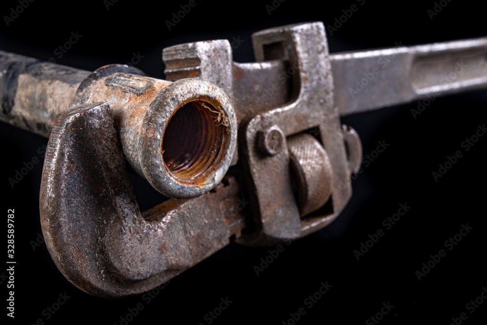 Old dirty pipe and hydraulic wrench. Accessories and tools for a plumber. Old dirty pipe and hydraulic wrench. Accessories and tools for a plumber.