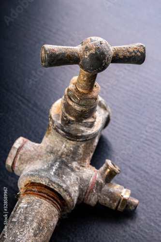 Old dirty metal water tap. Accessories and tools for a plumber.