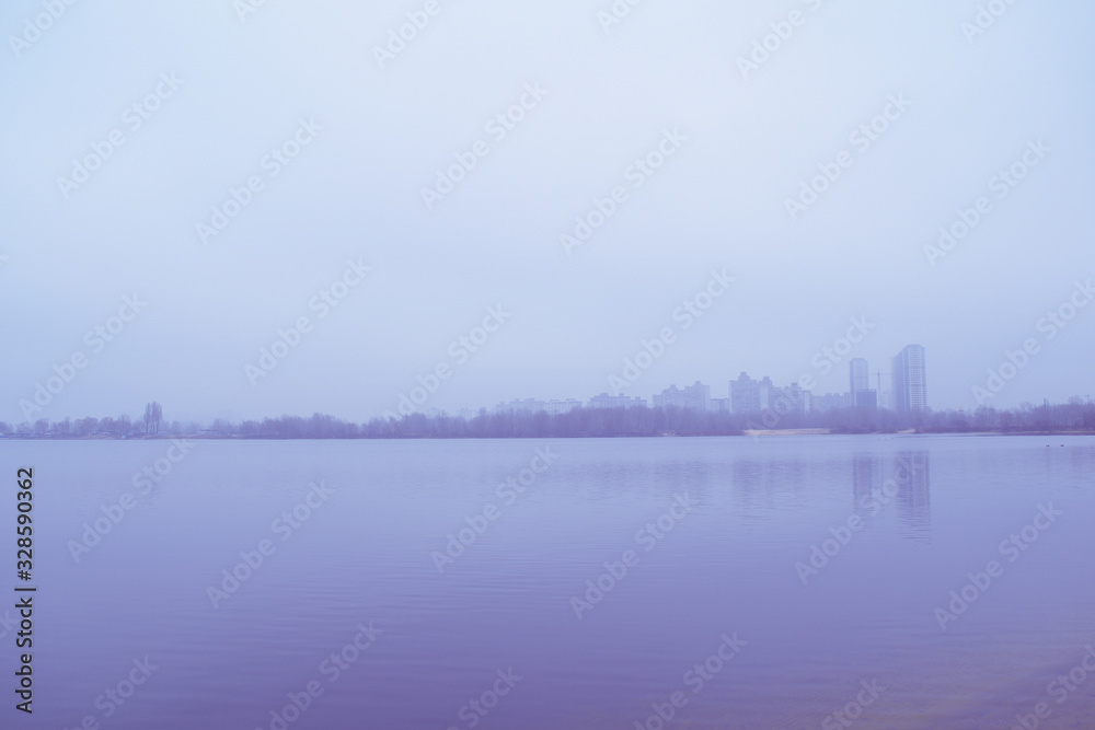 View across the lake in the fog on the city in the distance