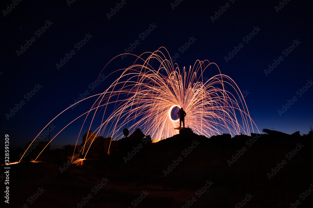 Fotka „rain of golden sparks of steel wool set on fire. Figure of a man