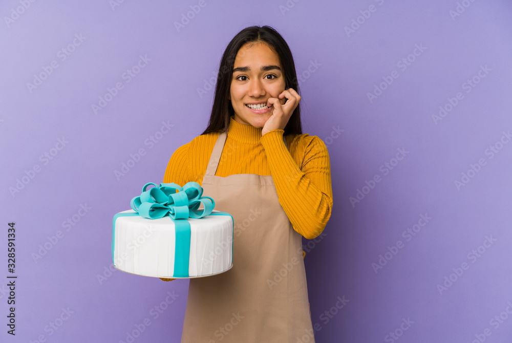 Young asian woman holding a cake isolated biting fingernails, nervous and very anxious. Young asian woman holding a cake isolated biting fingernails, nervous and very anxious.