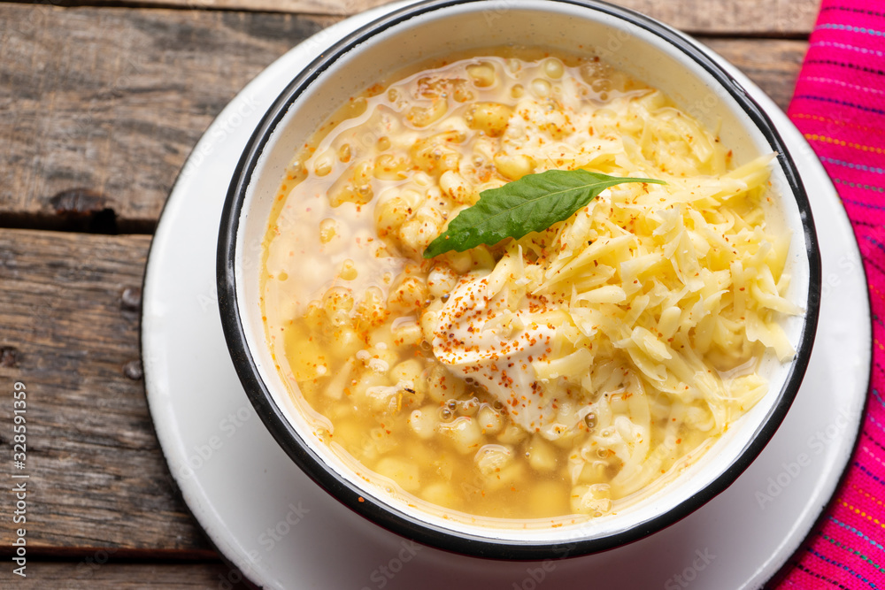 Mexican corn grain boiled also called esquites with cheese and mayonnaise on wooden background Mexican corn grain boiled also called esquites with cheese and mayonnaise on wooden background