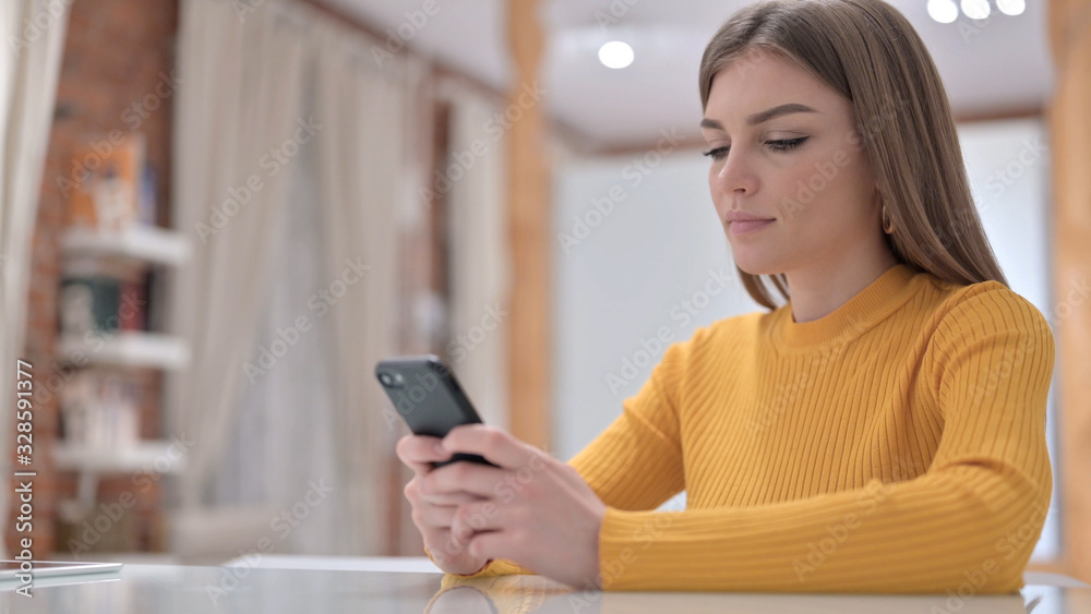 Cheerful Creative Young Woman using Smartphone Cheerful Creative Young Woman using Smartphone