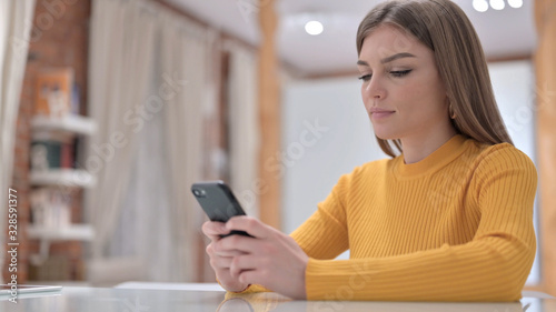 Cheerful Creative Young Woman using Smartphone