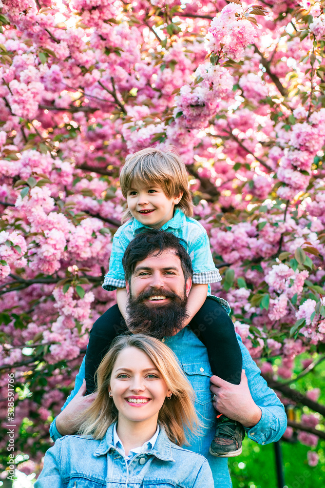 Fototapeta premium Portrait of Happy family outdoors. Mother, father and son. Young happy family of three having fun together outdoor.