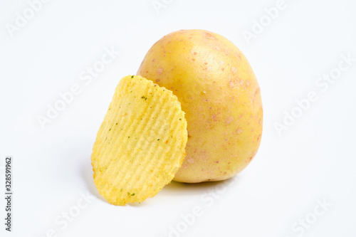 Fluted chips with spices leaned on peeled potatoes on a white background. Isolated.