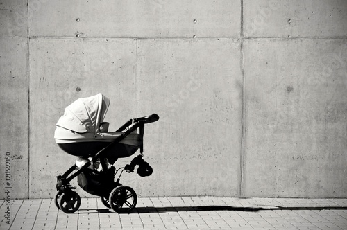 Baby carriage in front of concrete wall