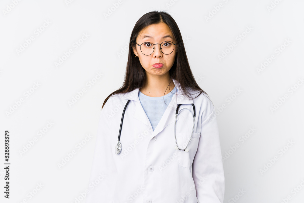 Young doctor chinese woman isolated shrugs shoulders and open eyes confused. Young doctor chinese woman isolated shrugs shoulders and open eyes confused.