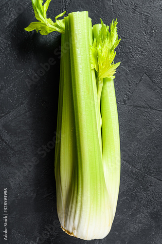Celery vegetable on wood tray.  Black background. Top view