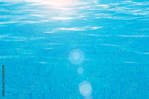 Blue pool surface pool water background with sun reflection