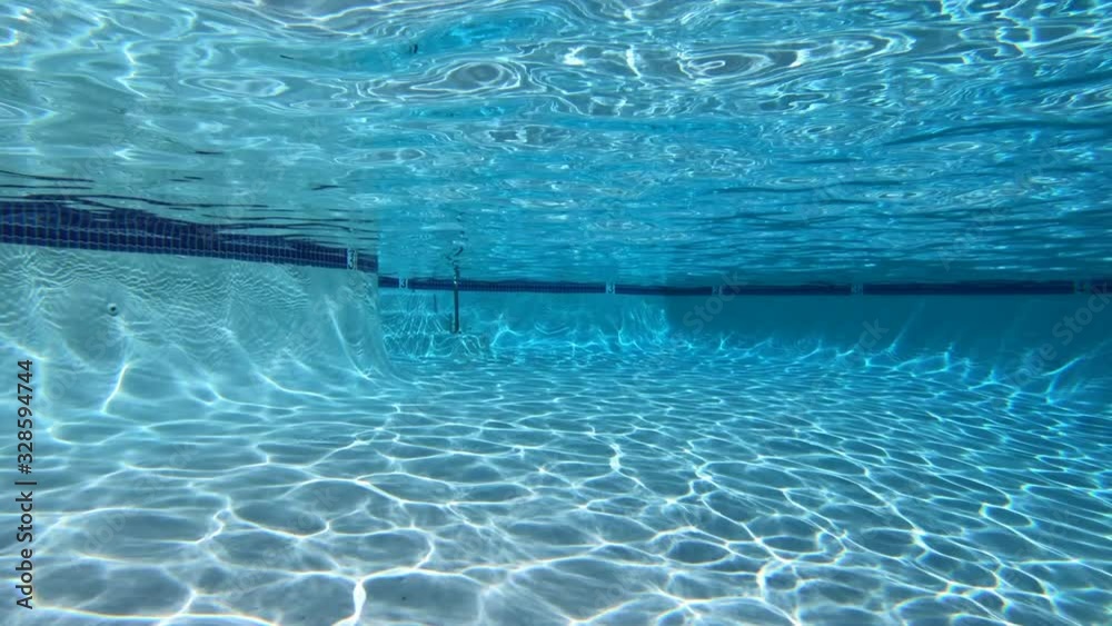 Moving underwater view of sunlight patterns in clean suburban swimming pool. Moving underwater view of sunlight patterns in clean suburban swimming pool.