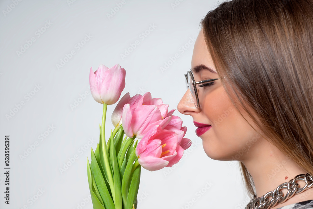 Young beautiful girl with pink tulips in her hands.