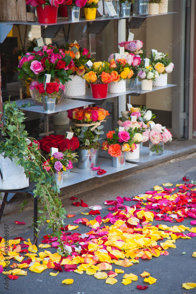 Various bright bouquets on a flower shop window. Rose petals lie on the pavement. Gift. Birthday, holiday, international women's day, mother's day Various bright bouquets on a flower shop window. Rose petals lie on the pavement. Gift. Birthday, holiday, international women's day, mother's day