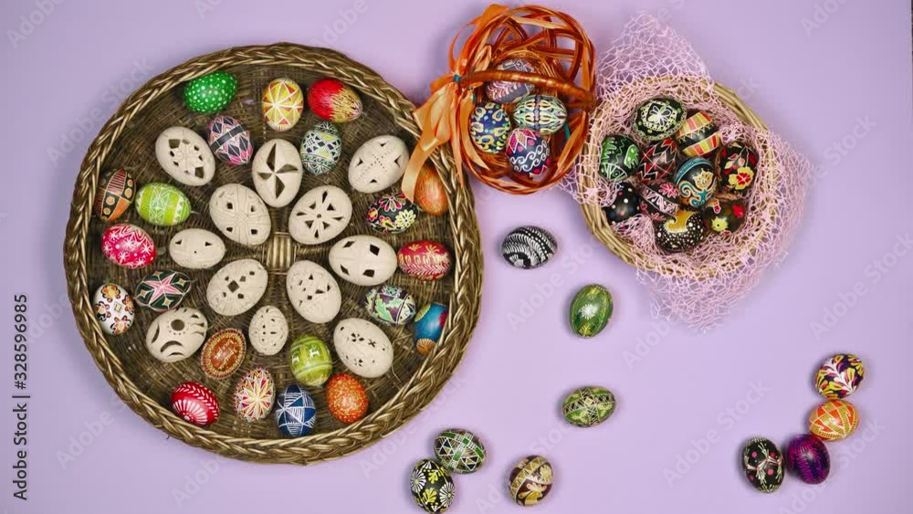 Colored eggs on a table near a basket of Easter eggs on a blue background. Easter is holy. 4k