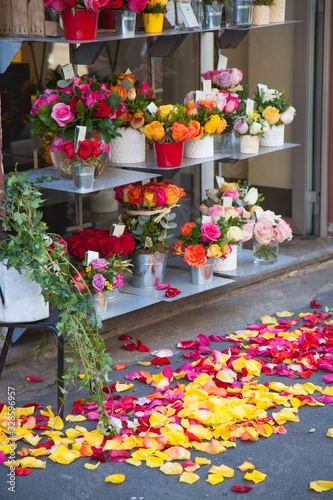 Various bright bouquets on a flower shop window. Rose petals lie on the pavement. Gift. Birthday, holiday, international women's day, mother's day