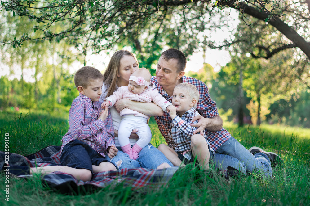 Happy large family picnic in the Park. Family outdoor recreation. Young parents and three children. Happy large family picnic in the Park. Family outdoor recreation. Young parents and three children.