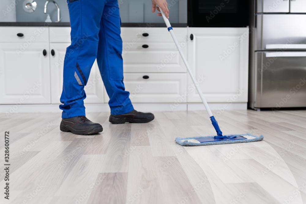 Fototapeta premium Man Mopping The Floor In Kitchen