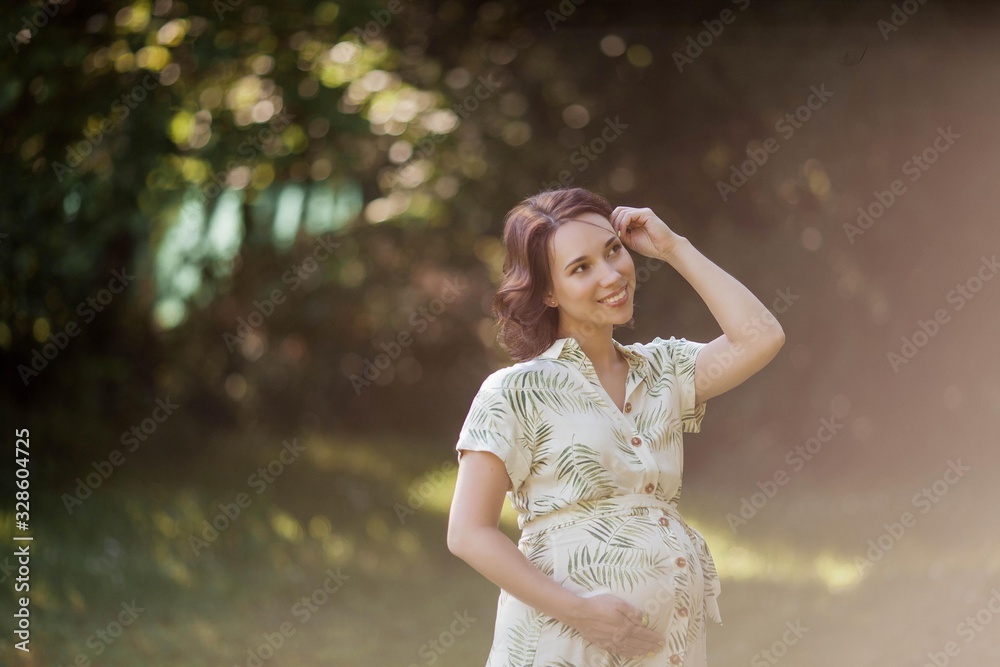 Portrait of a beautiful young pregnant woman in eco dress. Motherhood. A family. Summer.