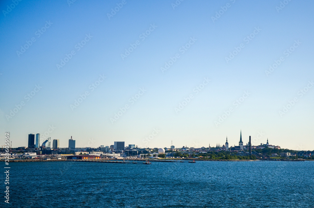  View of Old town Tallinn from cruise ship. The calm expanse of the Baltic Sea. In the distance, modern buildings the ancient cathedrals and tower on the coast. Estonia